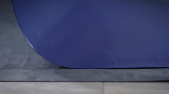 A blue decontamination mat being placed in a rubber frame.